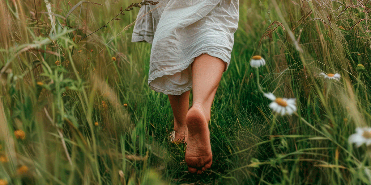 Mulher caminhando descalça na grama