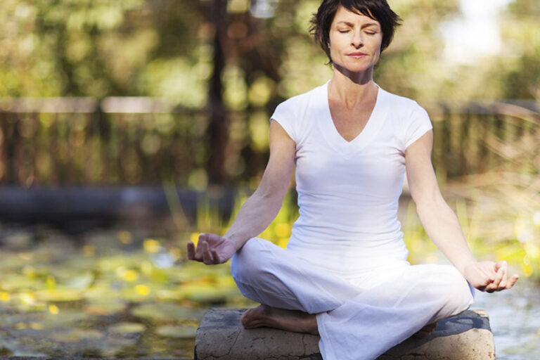 mulher sentada no parque meditando