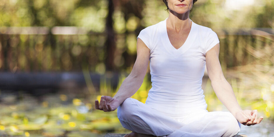 mulher sentada no parque meditando