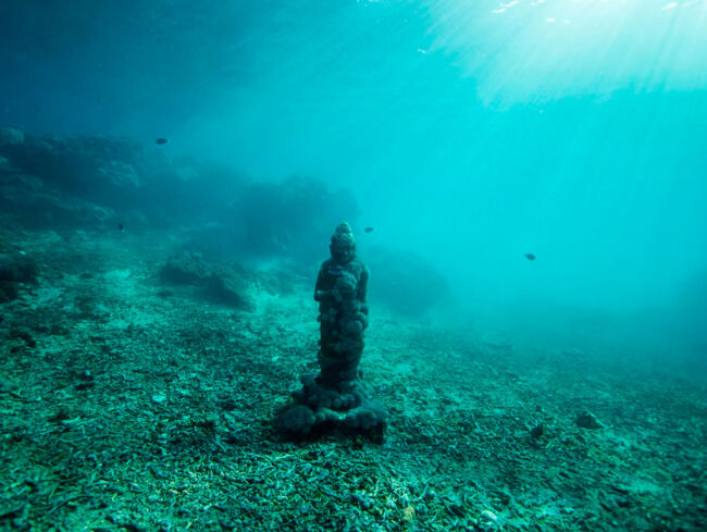 escultura de um buda no fundo do oceano