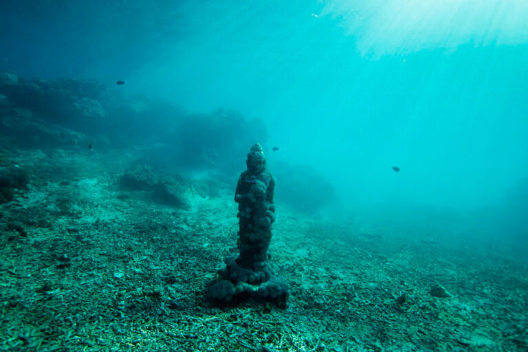 escultura de um buda no fundo do oceano
